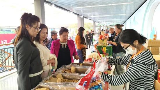 和田群众在河南省展区购买河南特色美食。通讯员 麦麦提艾力 摄